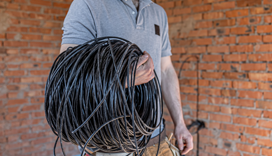 Homem com rolod e cabo de redes na mão